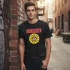 T-shirt preta de manga curta com o logótipo da banda Soundgarden estampado no peito. A estampa apresenta o nome da banda em letras vermelhas sobre um círculo amarelo estilizado com um triângulo central.