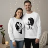 Sweatshirts unissexo casal Disney brancas com estampas pretas do Mickey e da Minnie que se completam formando um coração quando o casal está lado a lado.