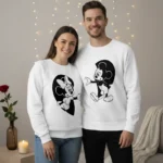 Sweatshirts unissexo casal Disney brancas com estampas pretas do Mickey e da Minnie que se completam formando um coração quando o casal está lado a lado.