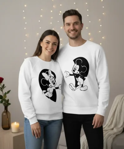 Sweatshirts unissexo casal Disney brancas com estampas pretas do Mickey e da Minnie que se completam formando um coração quando o casal está lado a lado.