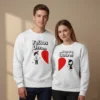 Casal veste sweatshirts brancas unissexo com design interativo de coração dividido e a frase em português 'Feitos Um Para o Outro.