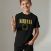T-shirt preta infantil com o logótipo amarelo do Nirvana e a "Smiley Face" no peito, em fundo branco.