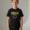 T-shirt preta infantil com o logótipo amarelo do Nirvana e a "Smiley Face" no peito, em fundo branco.